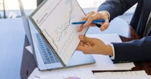 Business professionals discussing financial graphs and charts in an office setting.